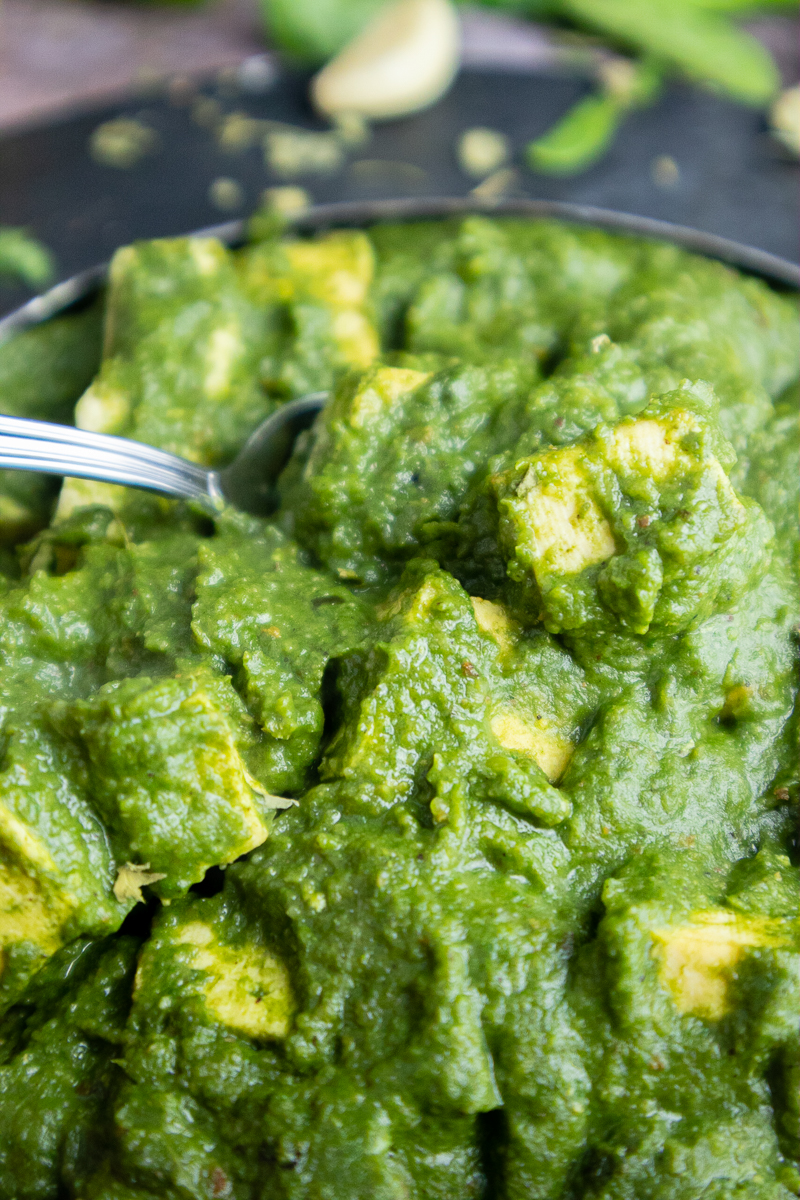 Vegan Punjabi Palak Paneer Recipe (Indian Spinach Curry) being eaten with a spoon