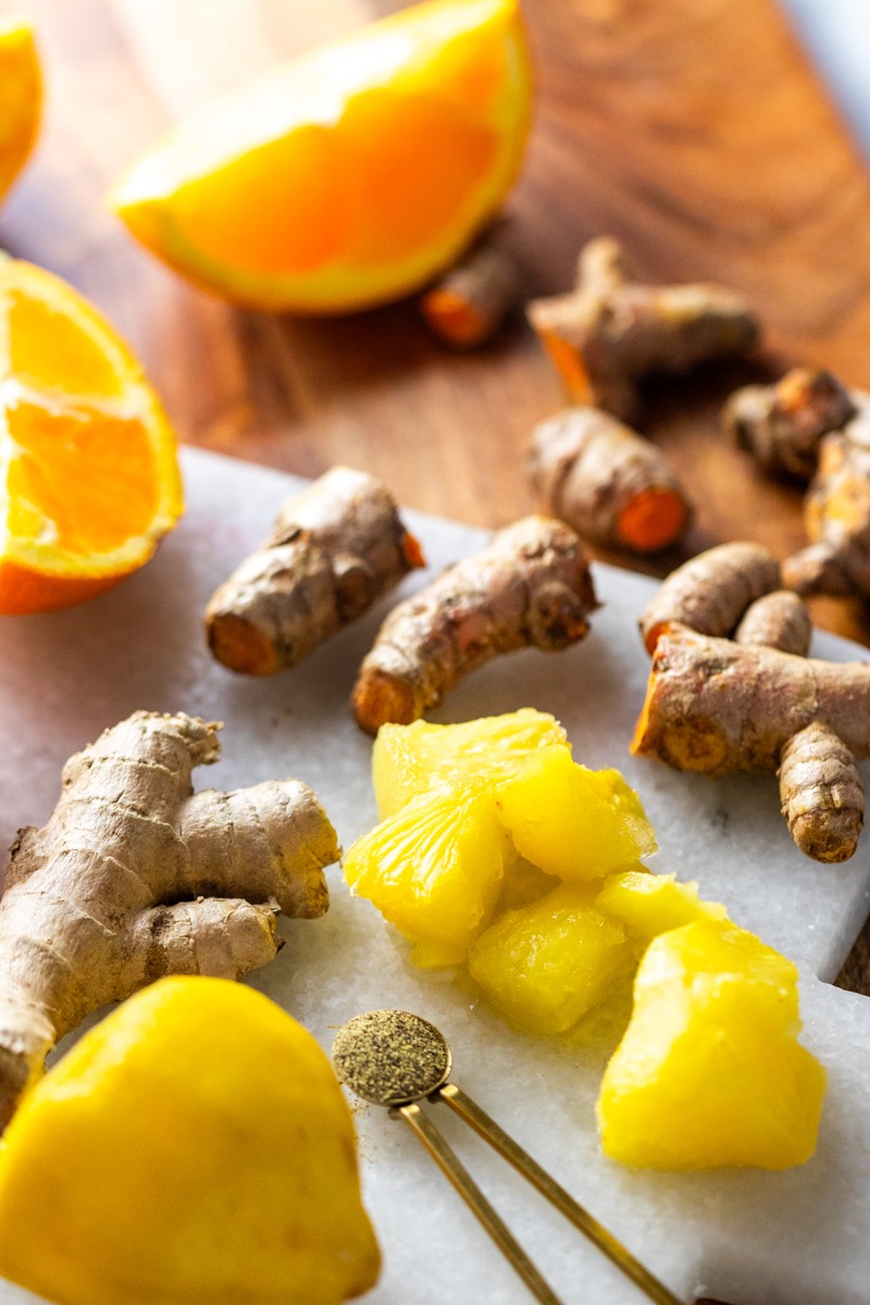 Lemon, Ginger & Turmeric Wellness Shot ingredients showing turmeric, pineapple, orange, lemon, ginger